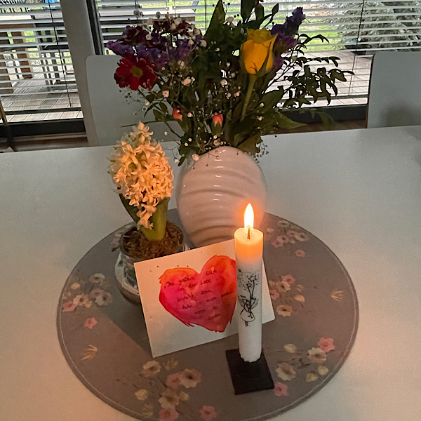 Blumenstrauß mit Kerze auf einem Tisch