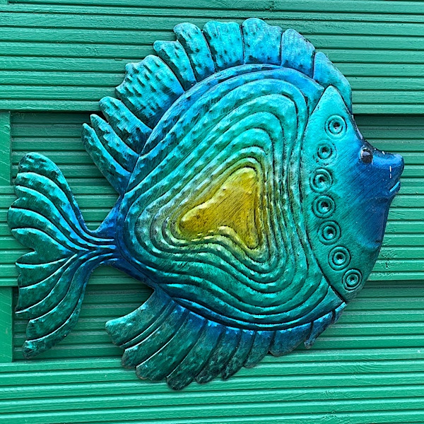 Blauer Fisch an einer grünen Holzwand