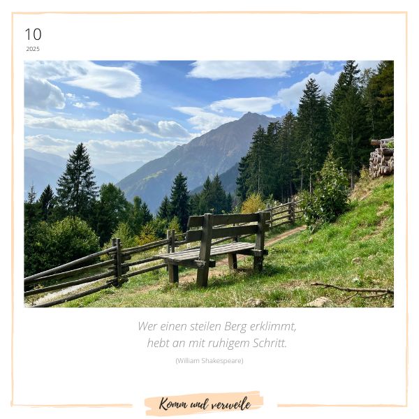 Holzbank mit Blick auf die Berge – Symbol für Innehalten und Reflexion, begleitet vom Zitat: "Wer einen steilen Berg erklimmt, hebt an mit ruhigem Schritt." – Komm und verweile
