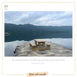 Bank am See mit Bergen in einer Spiegelung